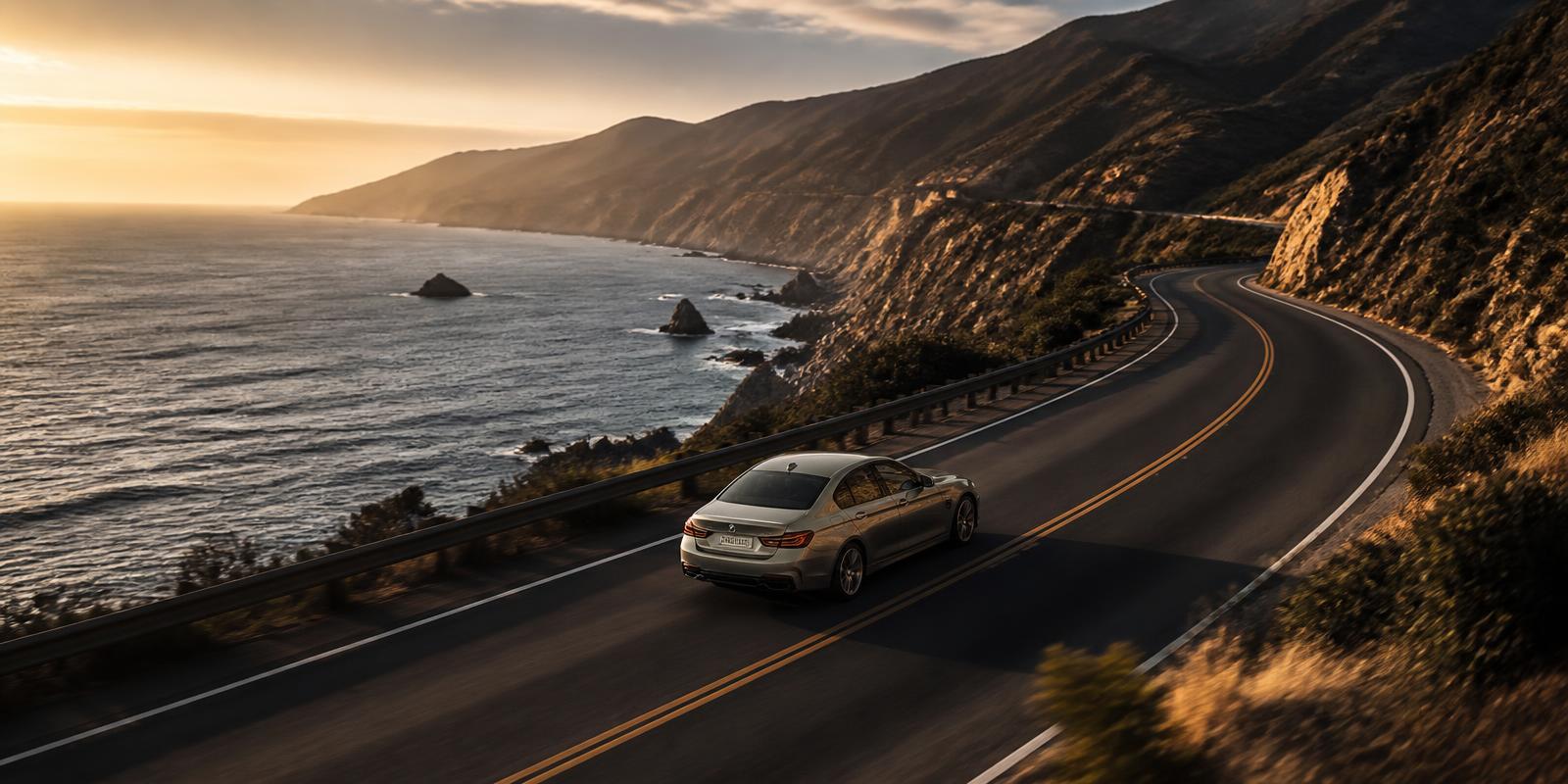 Vehículo ejecutivo recorriendo una carretera costera al atardecer